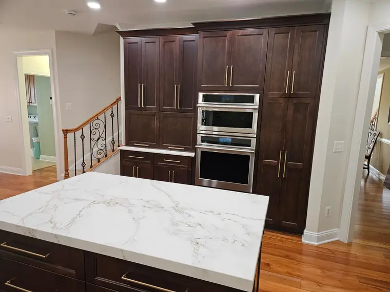 Calacatta gold island with dark mahogany cabinetry and brass hardware