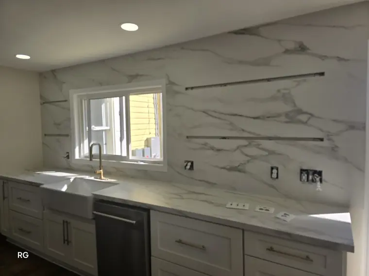 Full-slab backsplash galley kitchen with brass faucet