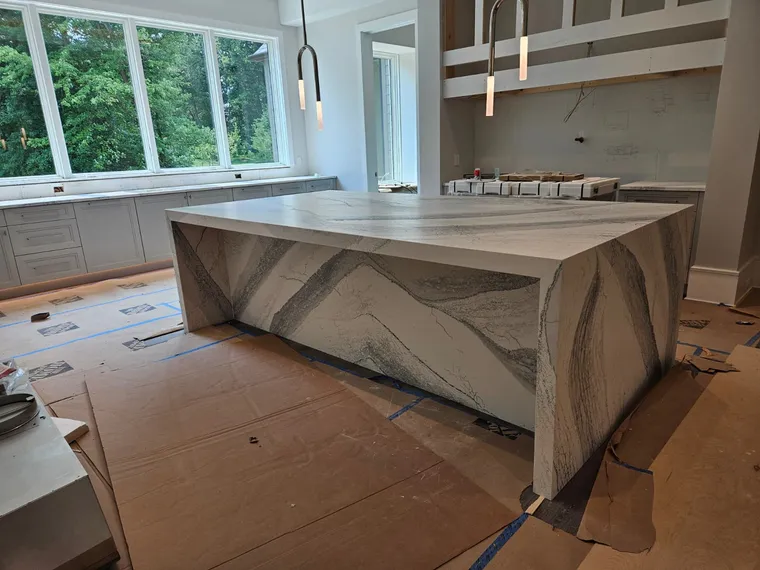 Custom kitchen with book-matched marble waterfall island and floor-to-ceiling windows