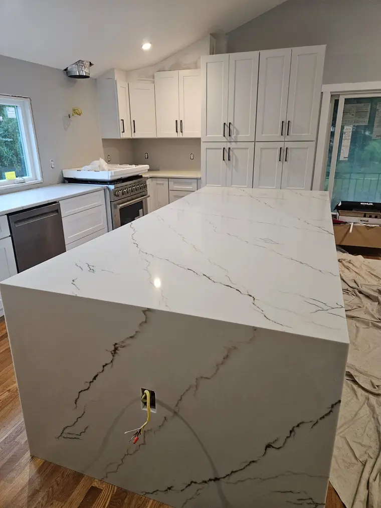 Calacatta waterfall island with white shaker cabinetry